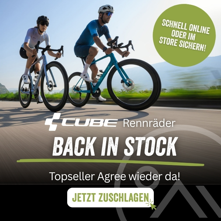 Zwei Rennradfahrer fahren auf einer sonnigen Straße. Im Vordergrund steht „Cube Rennräder – Back in Stock“, darunter der Hinweis „Topseller Agree wieder da“ sowie ein Button mit „Jetzt zuschlagen