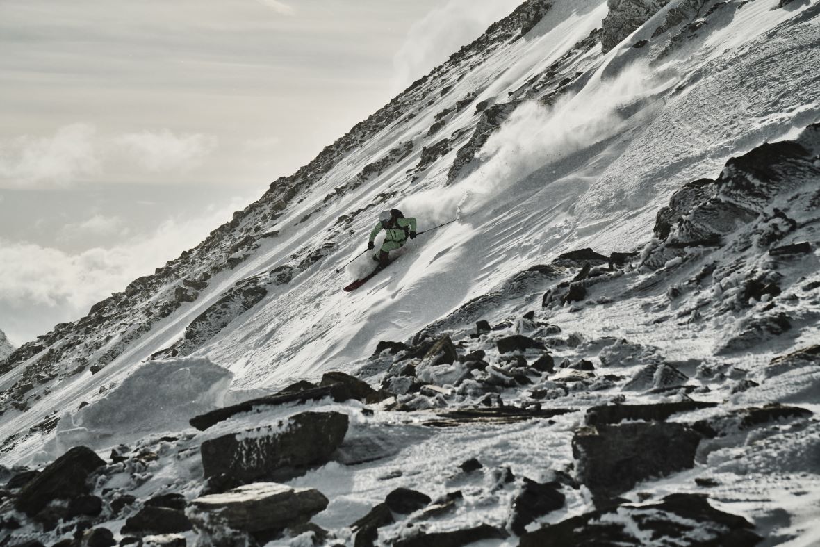 Ein Skifahrer der den Berg hinunter fährt