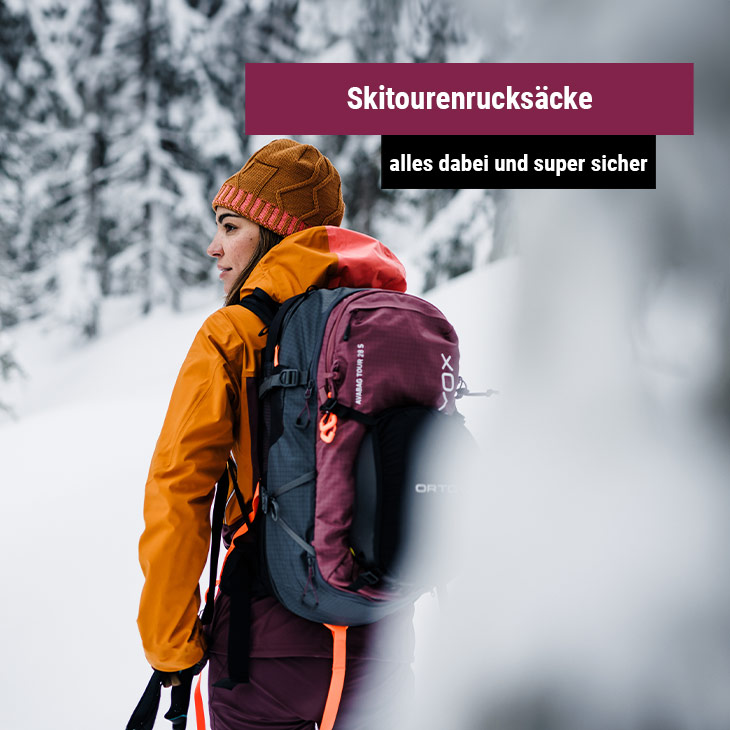 Person in orangefarbener Jacke mit Skitourenrucksack im verschneiten Wald, daneben ein Banner mit der Aufschrift 'Skitourenrucksäcke - alles dabei und super sicher'.
