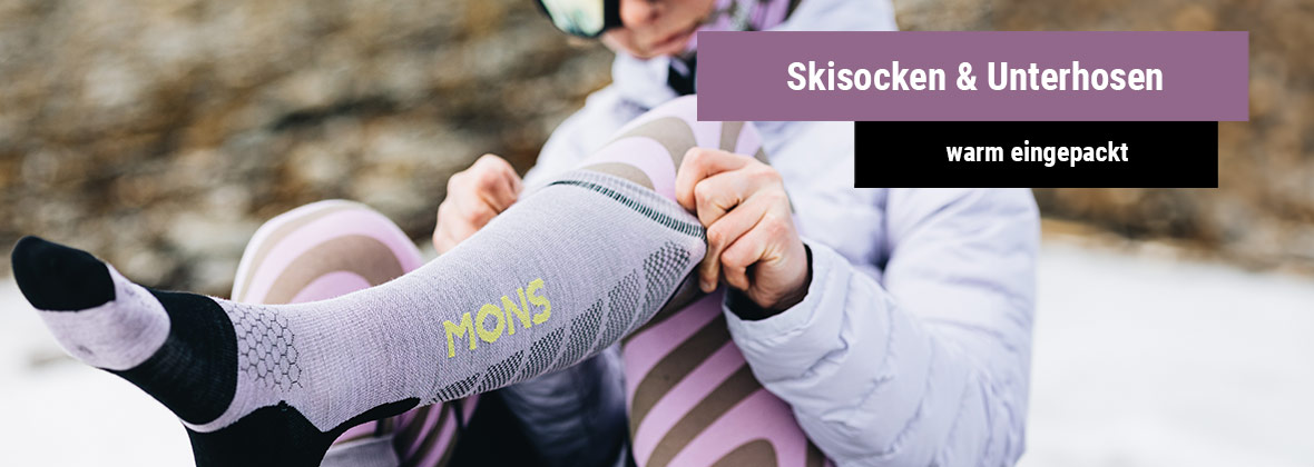 Frau die sich einen Socken von der Marke Mons Royale anzieht 