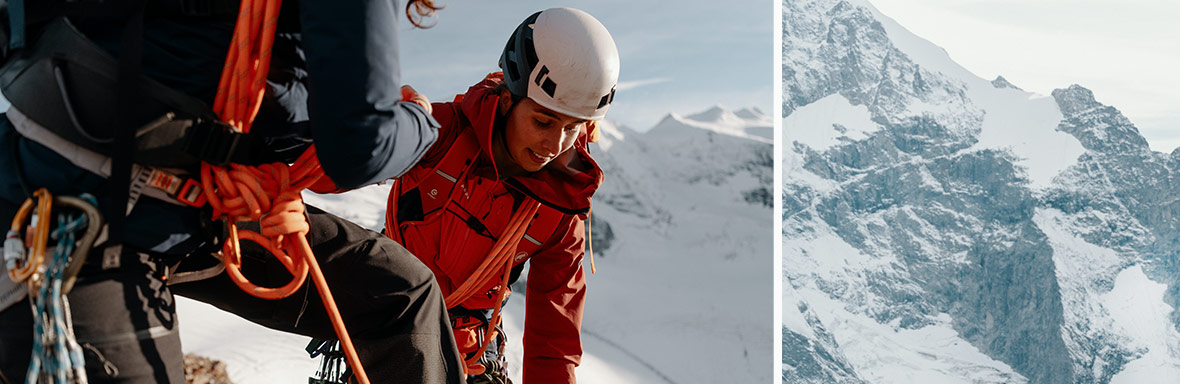 Eine Frau in roter Bergsteigerjacke und weißem Helm, die an einem gesicherten Seil auf einer verschneiten Bergspitze klettert. Der Hintergrund zeigt schneebedeckte Berge unter einem klaren Himmel.