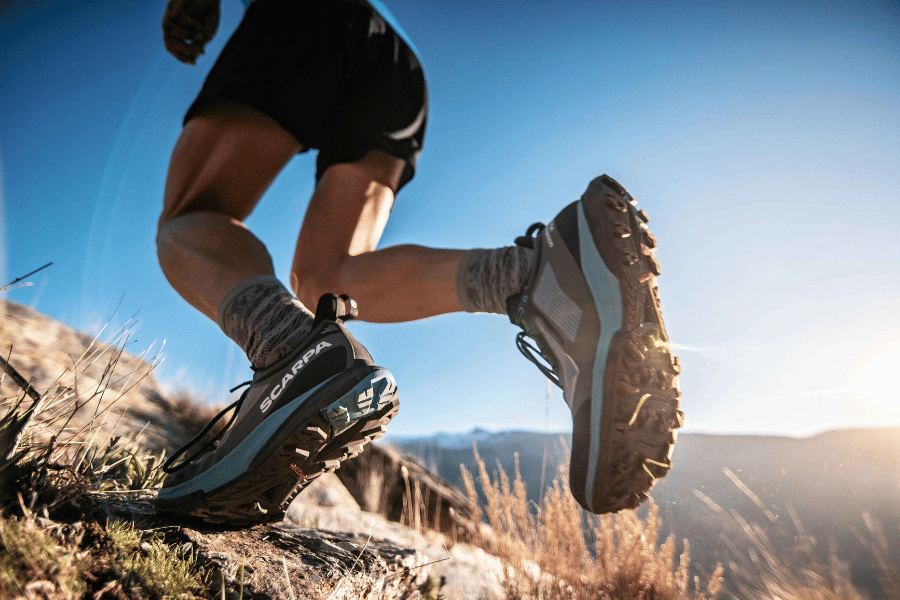 Wanderschuhe im Einsatz auf steinigem Bergtrail bei sonnigem Wetter