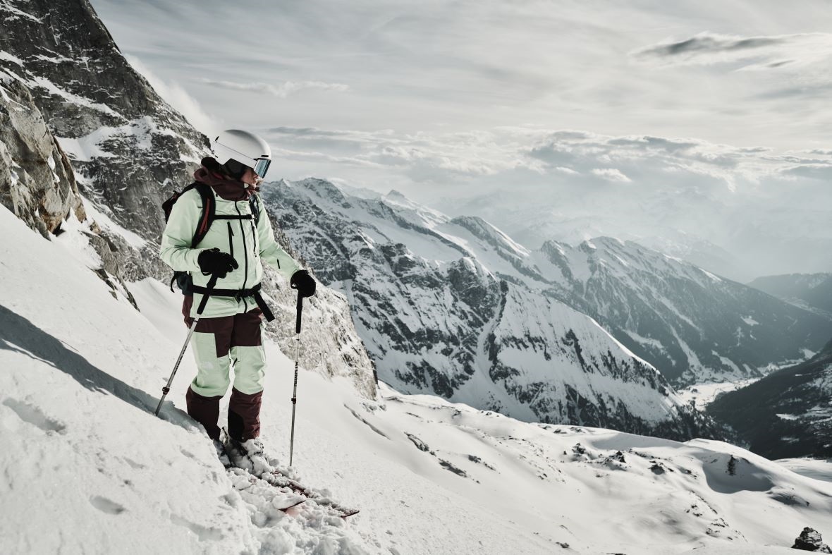 Skifahrer in roter Jacke auf verschneiter Berglandschaft